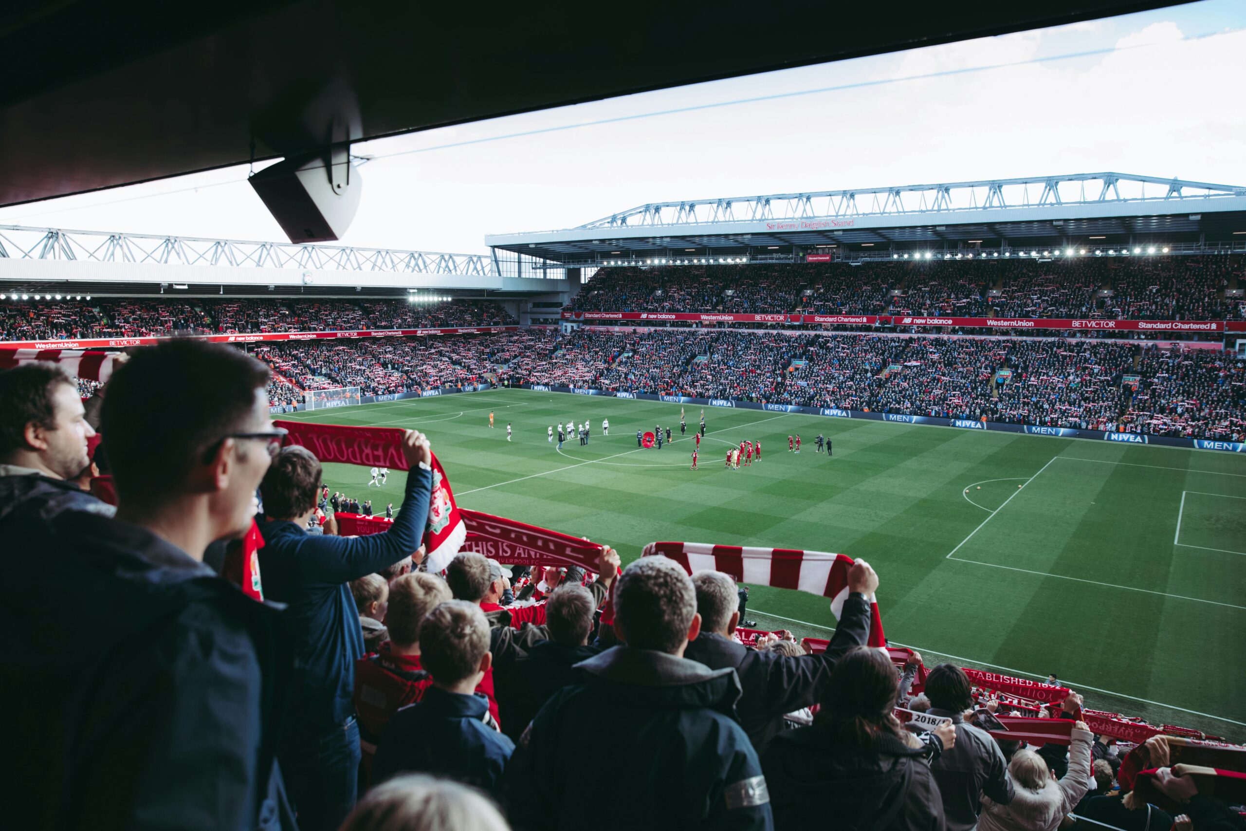 News Fans cheer as players take the field at a vibrant football stadium, creating an electric atmosphere.