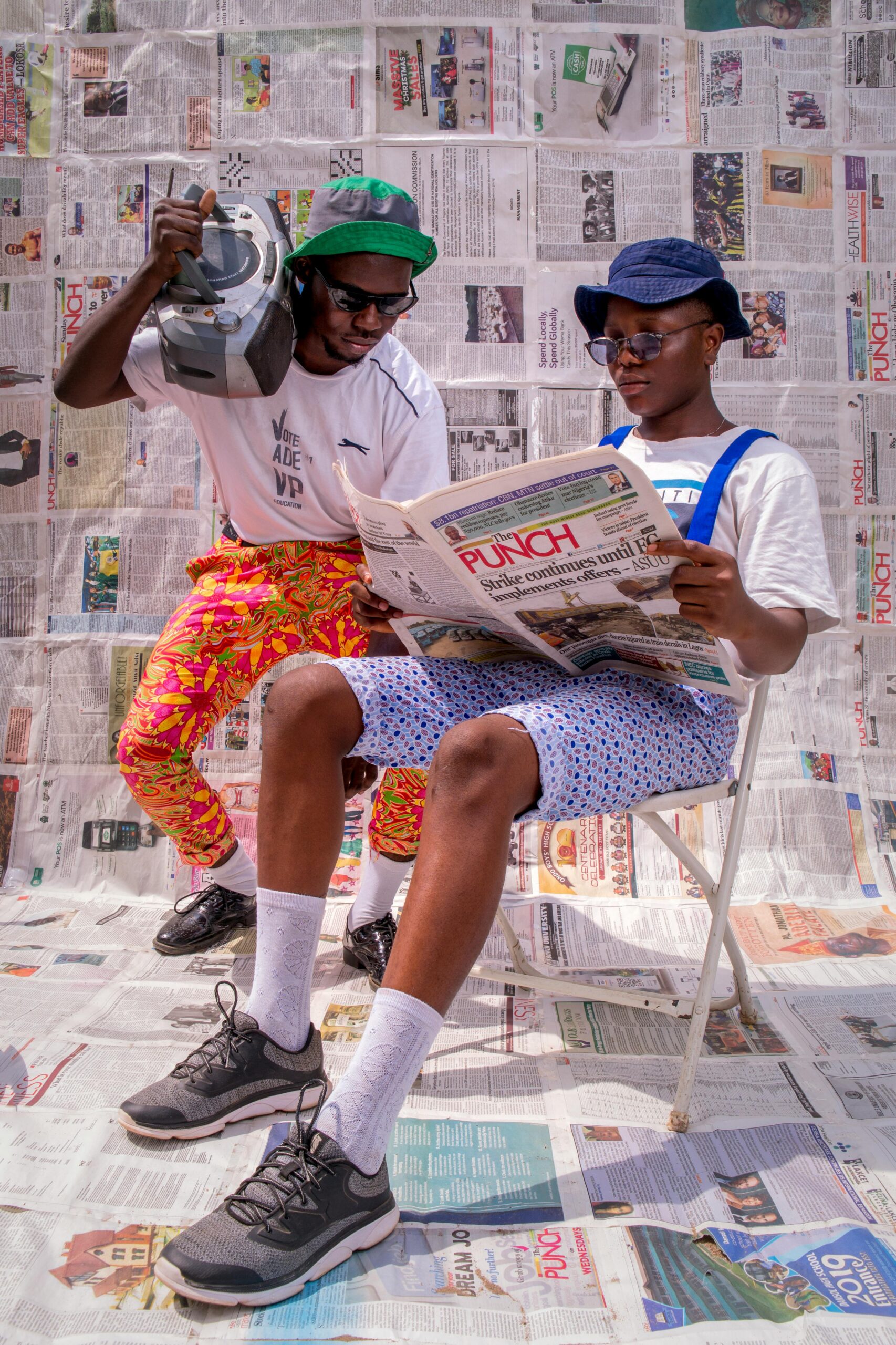 News Two stylish men in Nigeria enjoying a sunny day with vintage style and flair.